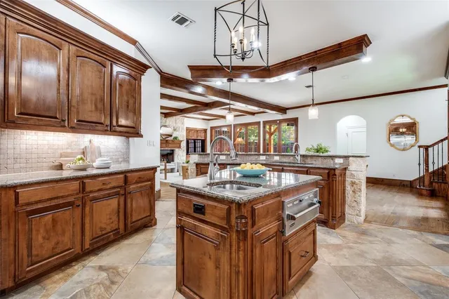 a kitchen with stainless steel appliances granite countertop a sink and wooden cabinets