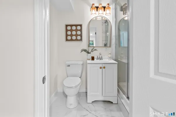 a bathroom with a toilet sink and mirror