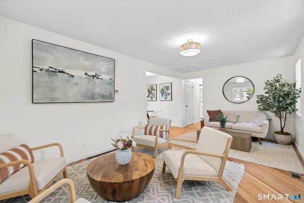 a living room with furniture a rug and a mirror