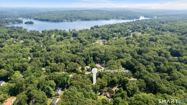 an aerial view of a houses with a yard and lake view