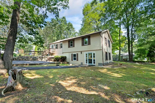 a view of a house with a big yard and large trees