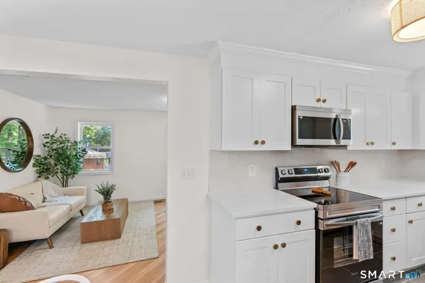a kitchen with stainless steel appliances a white stove top oven and a white cabinets
