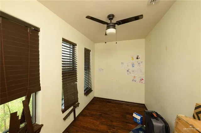 a view of a livingroom with wooden floor and a ceiling fan