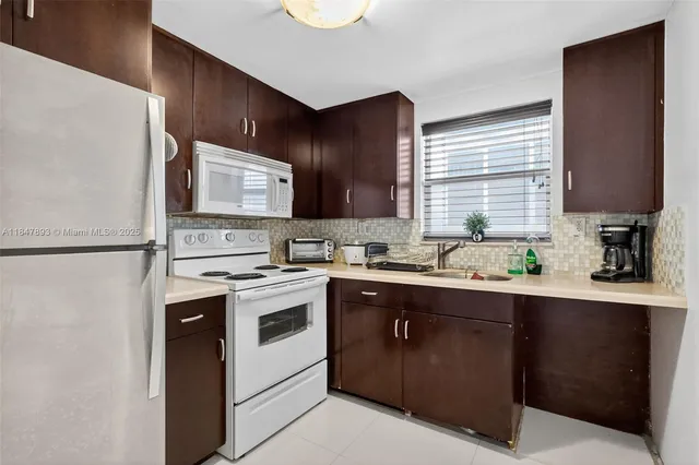 a kitchen with a sink a stove a refrigerator and cabinets
