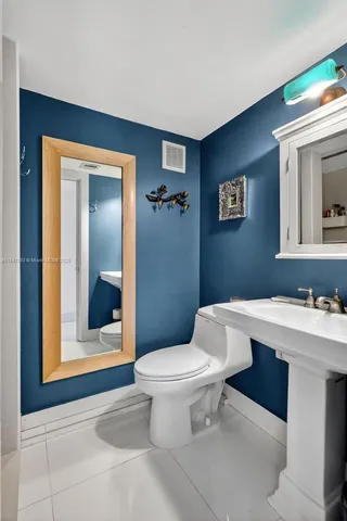 a bathroom with a toilet a sink and mirror
