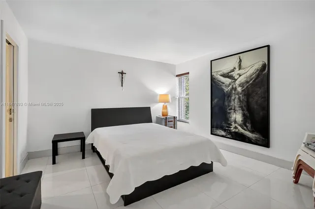 a bedroom with a large bed and a painting on the wall