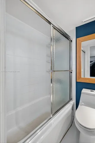 a bathroom with a toilet and a shower