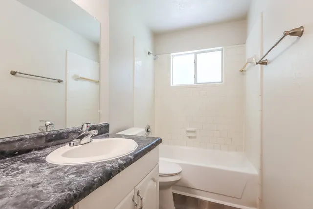 a bathroom with a granite countertop sink toilet and shower