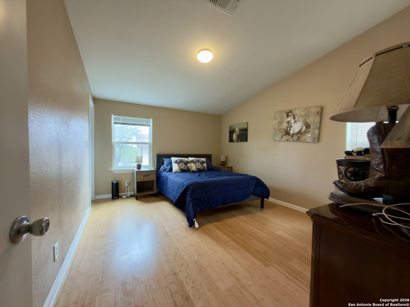 946 Frontier Lane Bandera, TX 78003 - Photo 18 of 48 a spacious bedroom with a bed and wooden floor