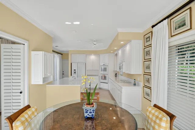 a large white kitchen with a large window and stainless steel appliances