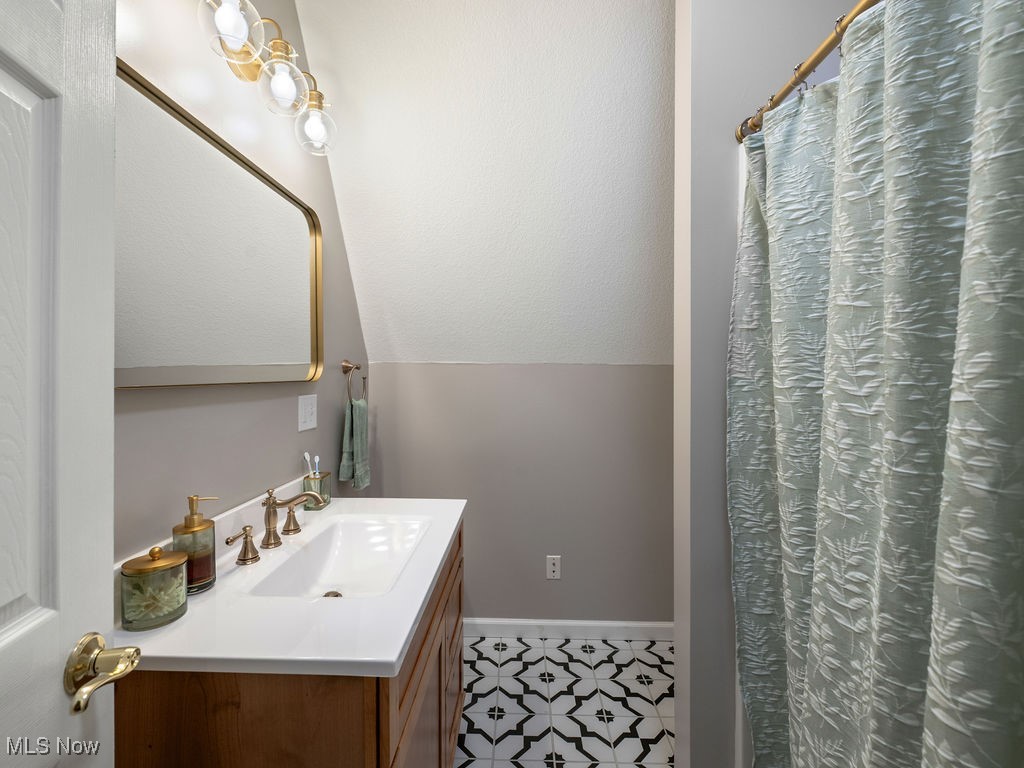 469 Vincent Hill Road Cairo, WV 26337 - Photo 32 of 48 Bathroom featuring baseboards, vaulted ceiling, and vanity