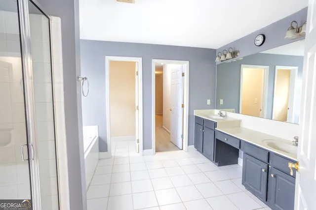 a large bathroom with a sink a mirror and a bathtub