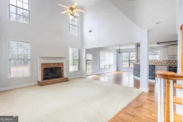 a view of an empty room with fireplace and a window