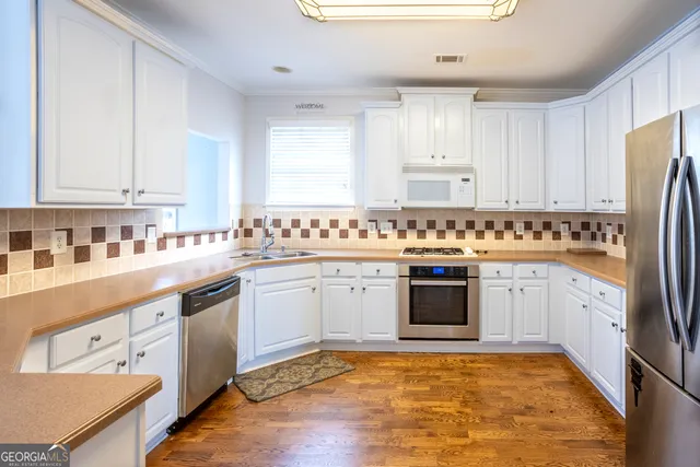 a kitchen with stainless steel appliances granite countertop a stove a sink dishwasher and a refrigerator