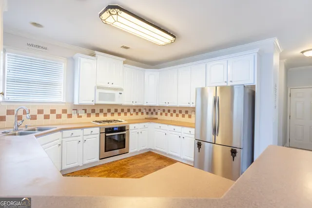 a kitchen with a refrigerator sink and cabinets