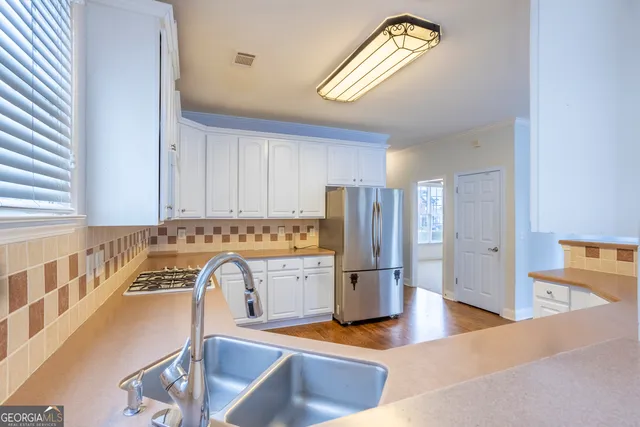 a view of kitchen with refrigerator stove and a sink