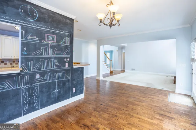 a view of a livingroom with wooden floor and a chandelier