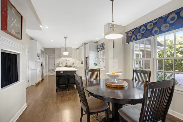 a dining room with furniture a chandelier and wooden floor