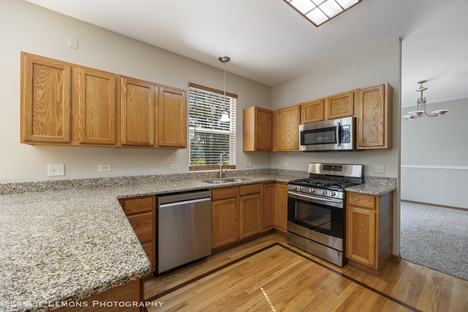 13141 Cinnamon Circle Plainfield, IL 60585 - Photo 13 of 35 a kitchen with stainless steel appliances granite countertop a stove a sink dishwasher and a microwave oven with wooden cabinets