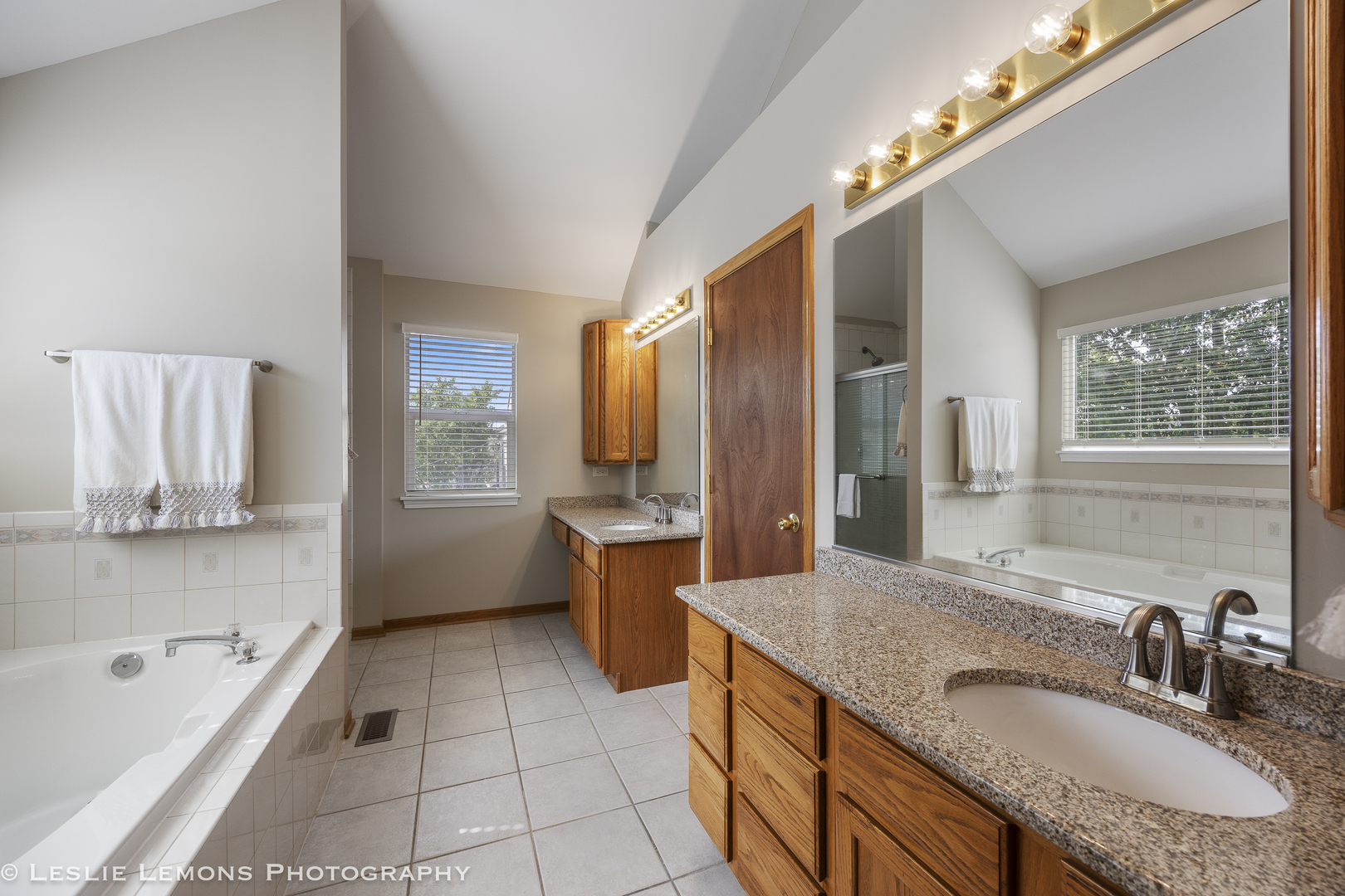 13141 Cinnamon Circle Plainfield, IL 60585 - Photo 23 of 35 a bathroom with a granite countertop sink mirror and a bathtub
