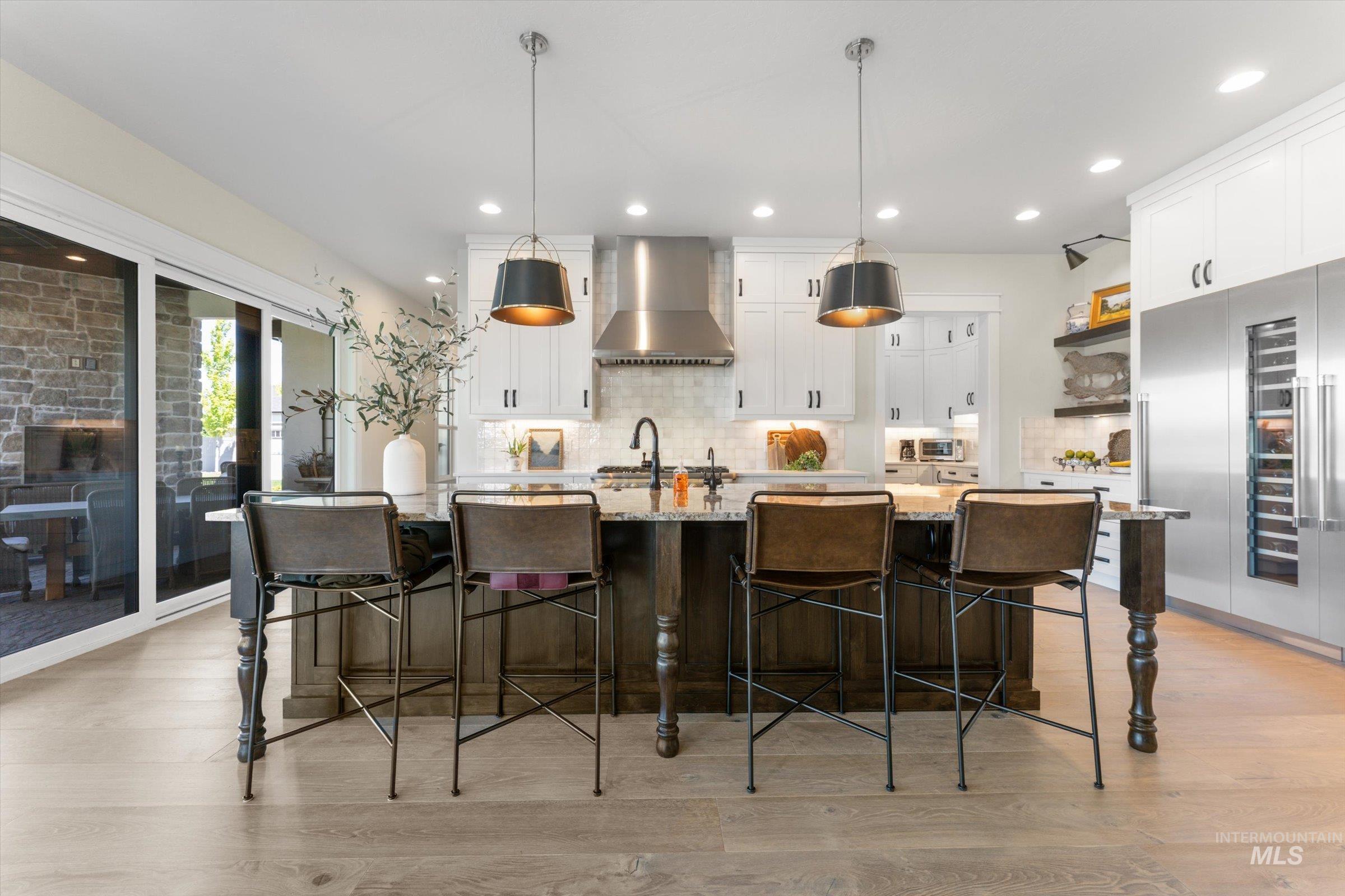 6585 South Pemberley Way Meridian, ID 83642 - Photo 12 of 43 Expansive kitchen island featuring a stone countertop, pendant lighting, and seating for four