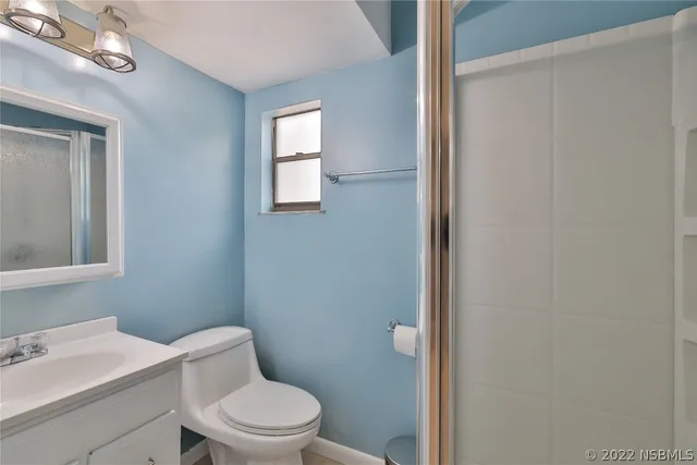 a view of an empty room with window and closet area