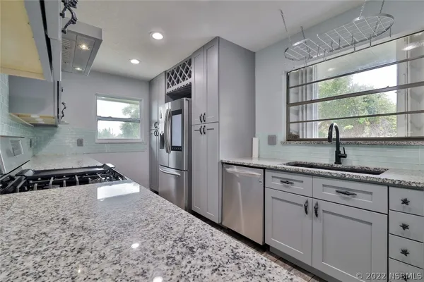 a kitchen with granite countertop white cabinets stainless steel appliances and sink