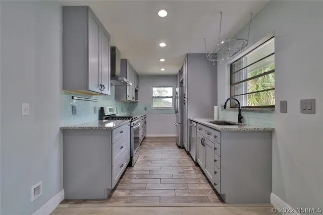 a view of empty room with wooden floor and windows