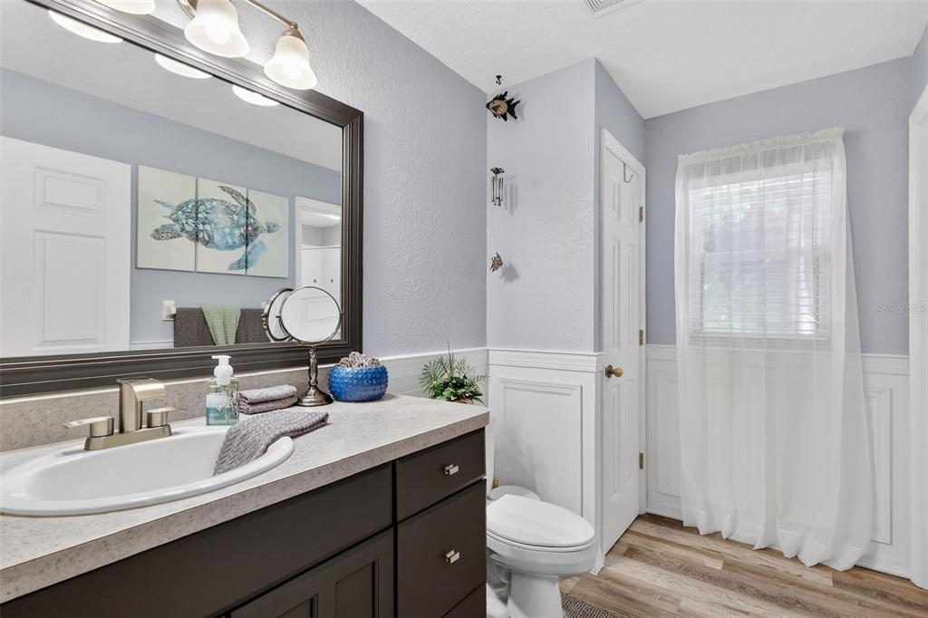 19703 Twin Ponds Road Umatilla, FL 32784 - Photo 30 of 62 a bathroom with a double vanity sink toilet and a mirror