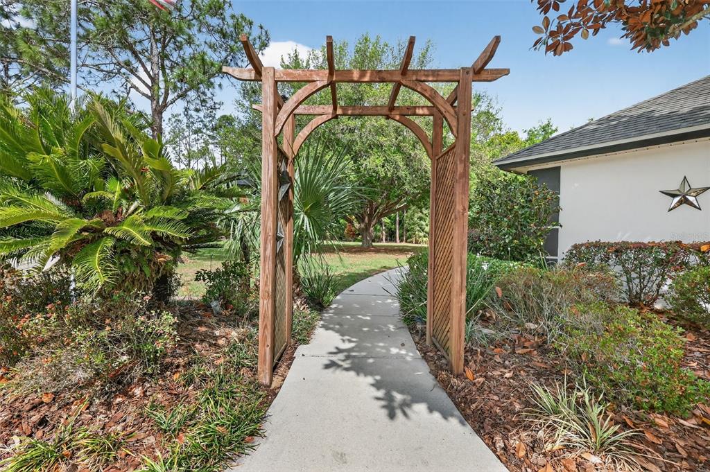19703 Twin Ponds Road Umatilla, FL 32784 - Photo 7 of 62 a view of a pathway of a house with a fountain and a tree