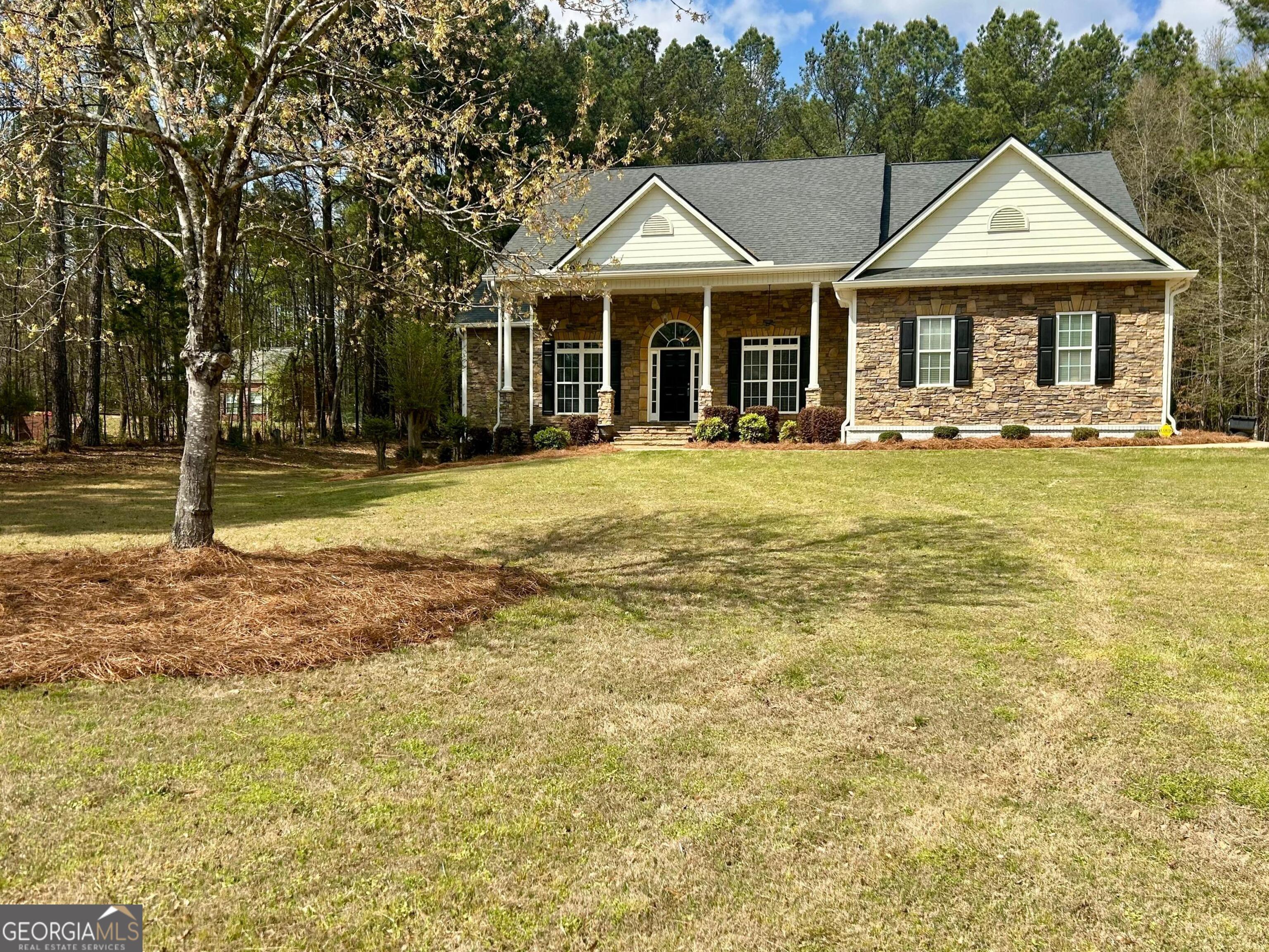 a front view of a residential houses with yard and green space