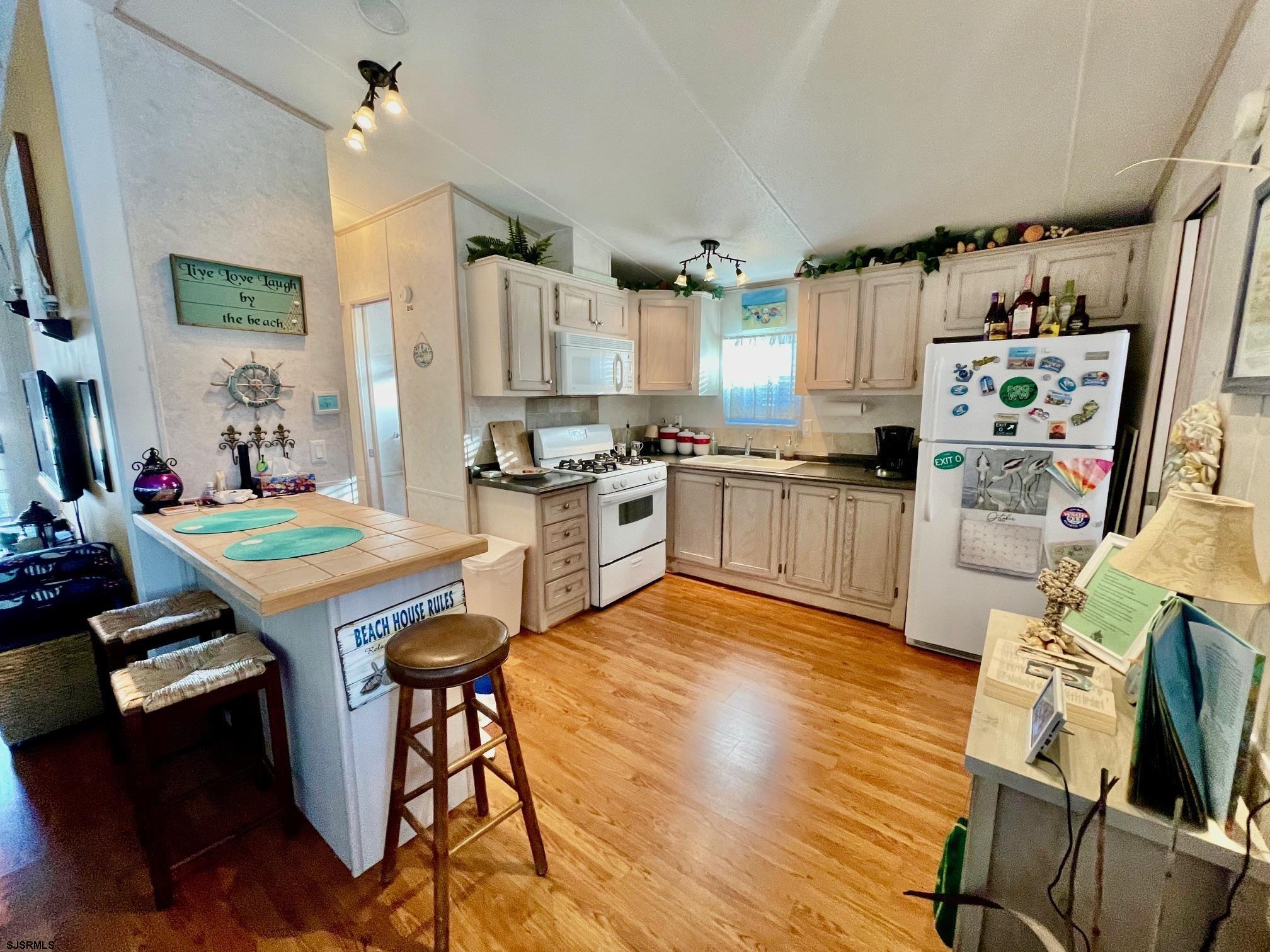 4100 Rte 9 South, Unit 19 Rio Grande, NJ 08242 - Photo 8 of 23 a kitchen with stainless steel appliances wooden floors stove and white cabinets