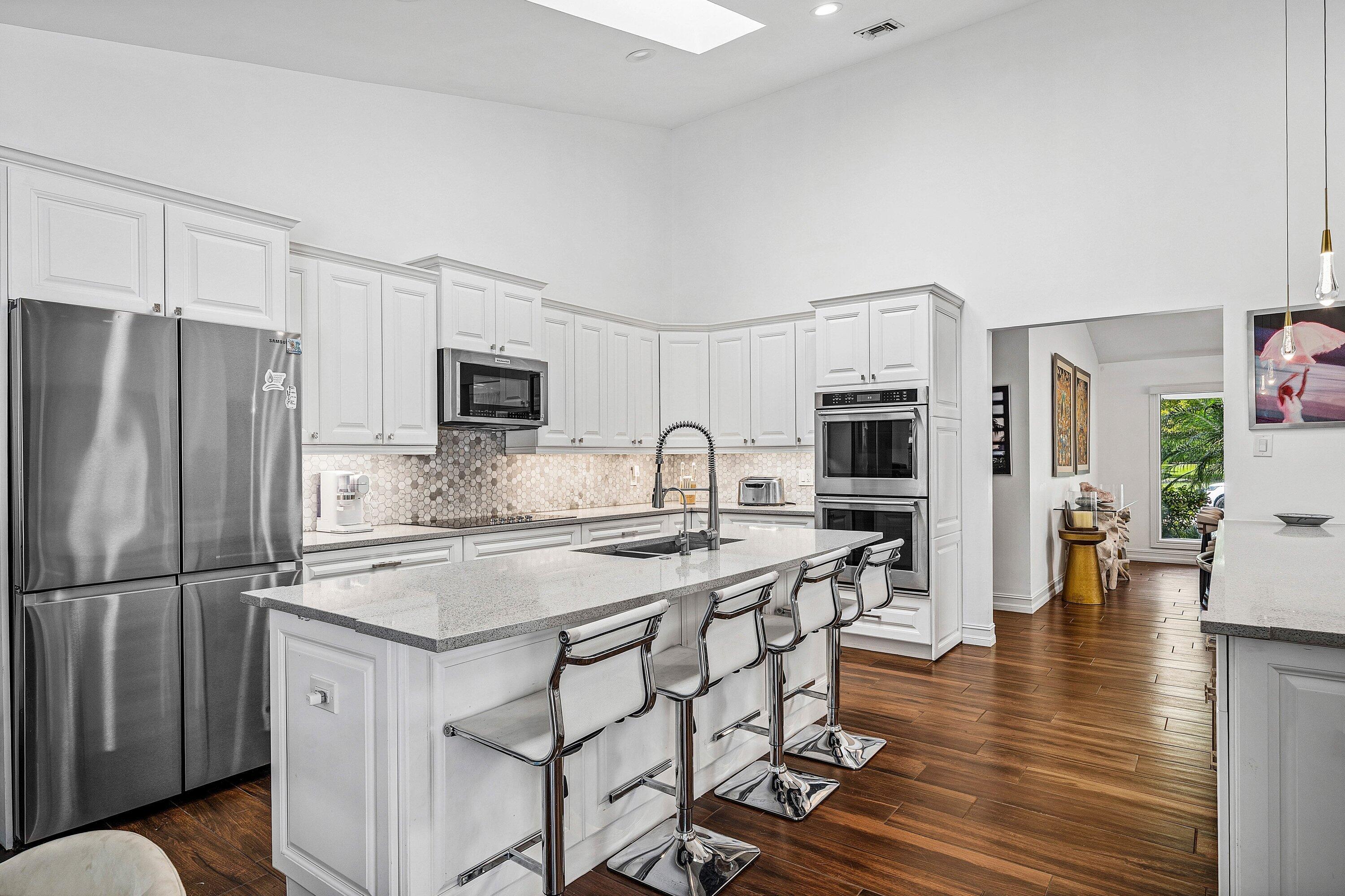 3030 Canterbury Drive Boca Raton, FL 33434 - Photo 11 of 45 a kitchen with stainless steel appliances granite countertop a refrigerator a stove a sink a dining table and chairs