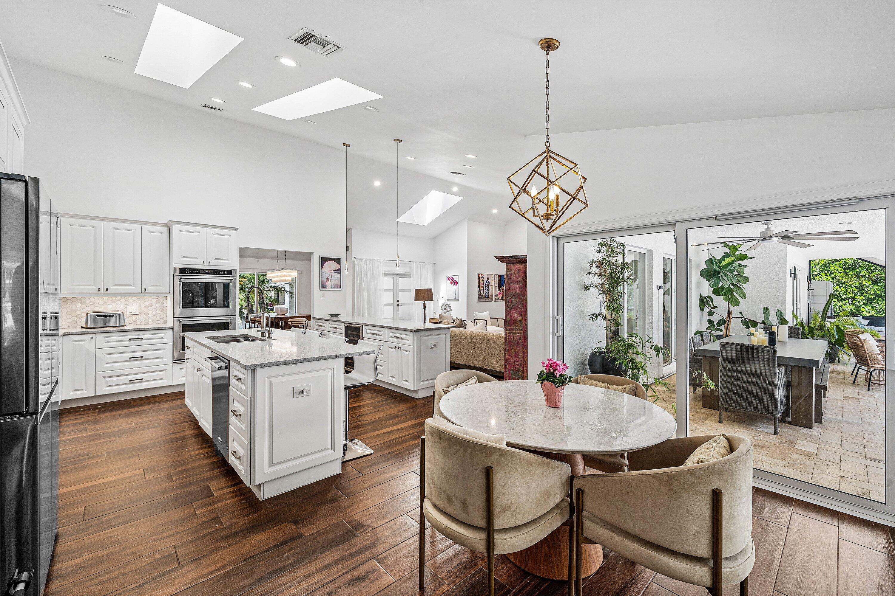 3030 Canterbury Drive Boca Raton, FL 33434 - Photo 13 of 45 a kitchen that has a table chairs stainless steel appliances and wooden floor
