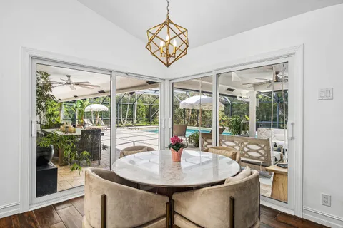 a view of a dining room with furniture large windows and wooden floor