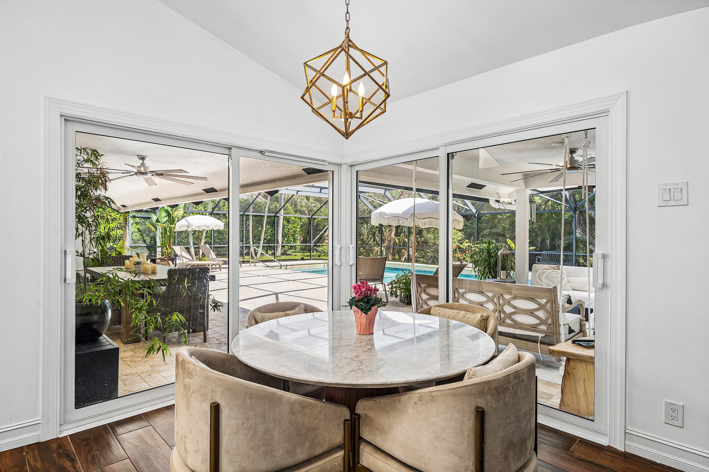 3030 Canterbury Drive Boca Raton, FL 33434 - Photo 14 of 45 a view of a dining room with furniture large windows and wooden floor