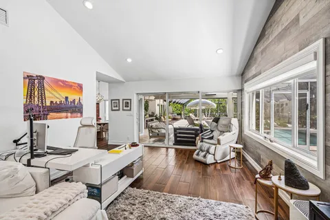 a living room with furniture a rug and a floor to ceiling window