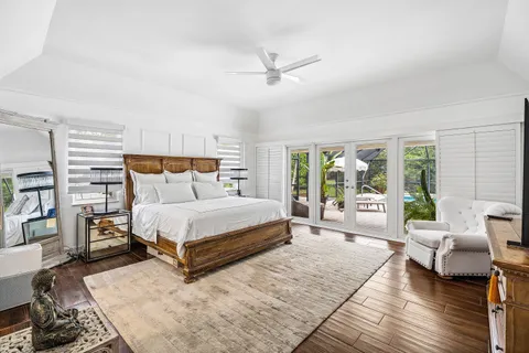 a bedroom with a bed couch and large window