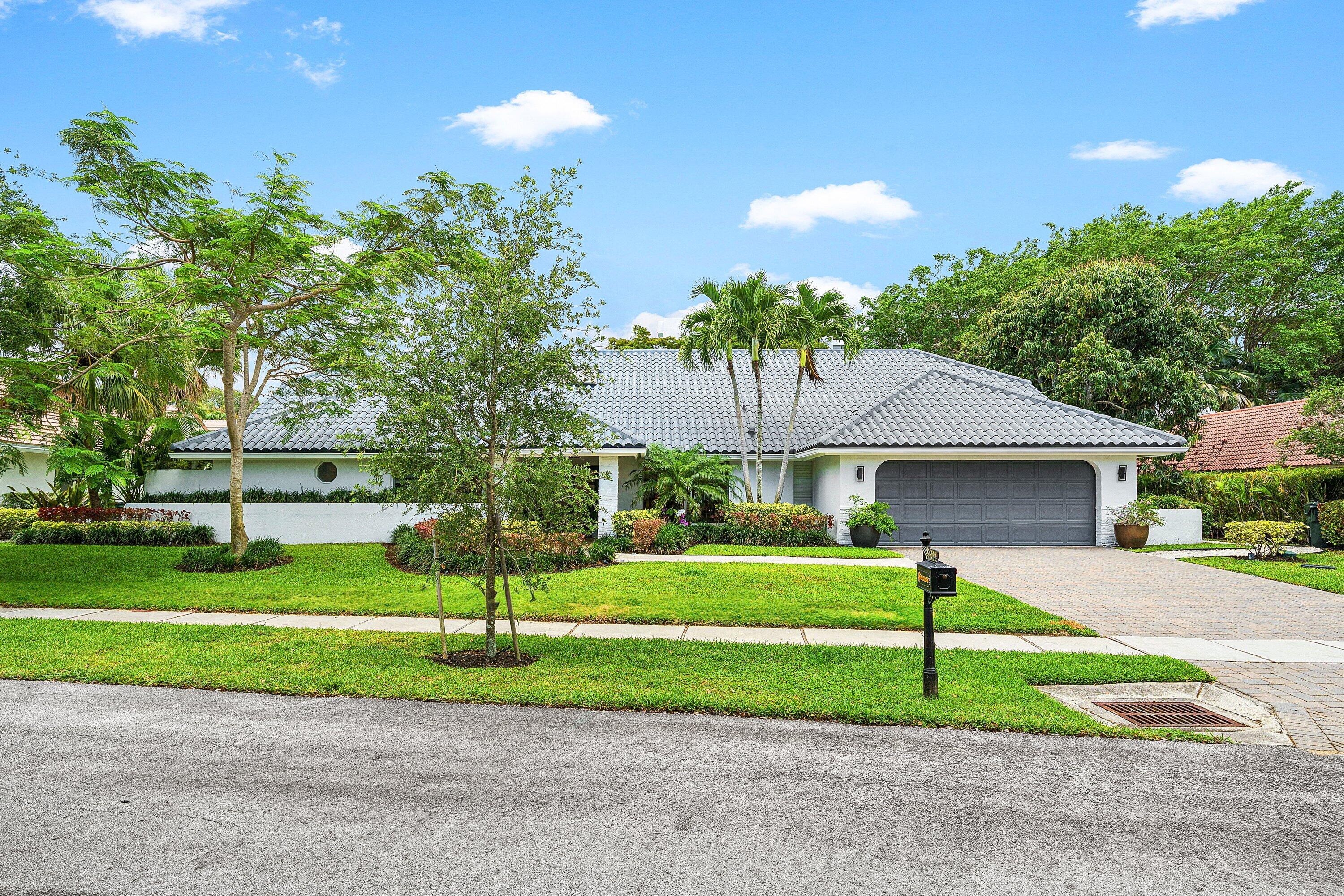 3030 Canterbury Drive Boca Raton, FL 33434 - Photo 2 of 45 a view of a house with a big yard and a large tree