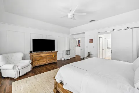 a bedroom with furniture and a flat screen tv