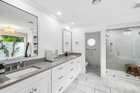a spacious bathroom with double sink and a mirror