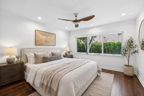 a bedroom with a large bed and a potted plant