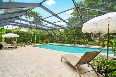 a view of a backyard with table and chairs under an umbrella