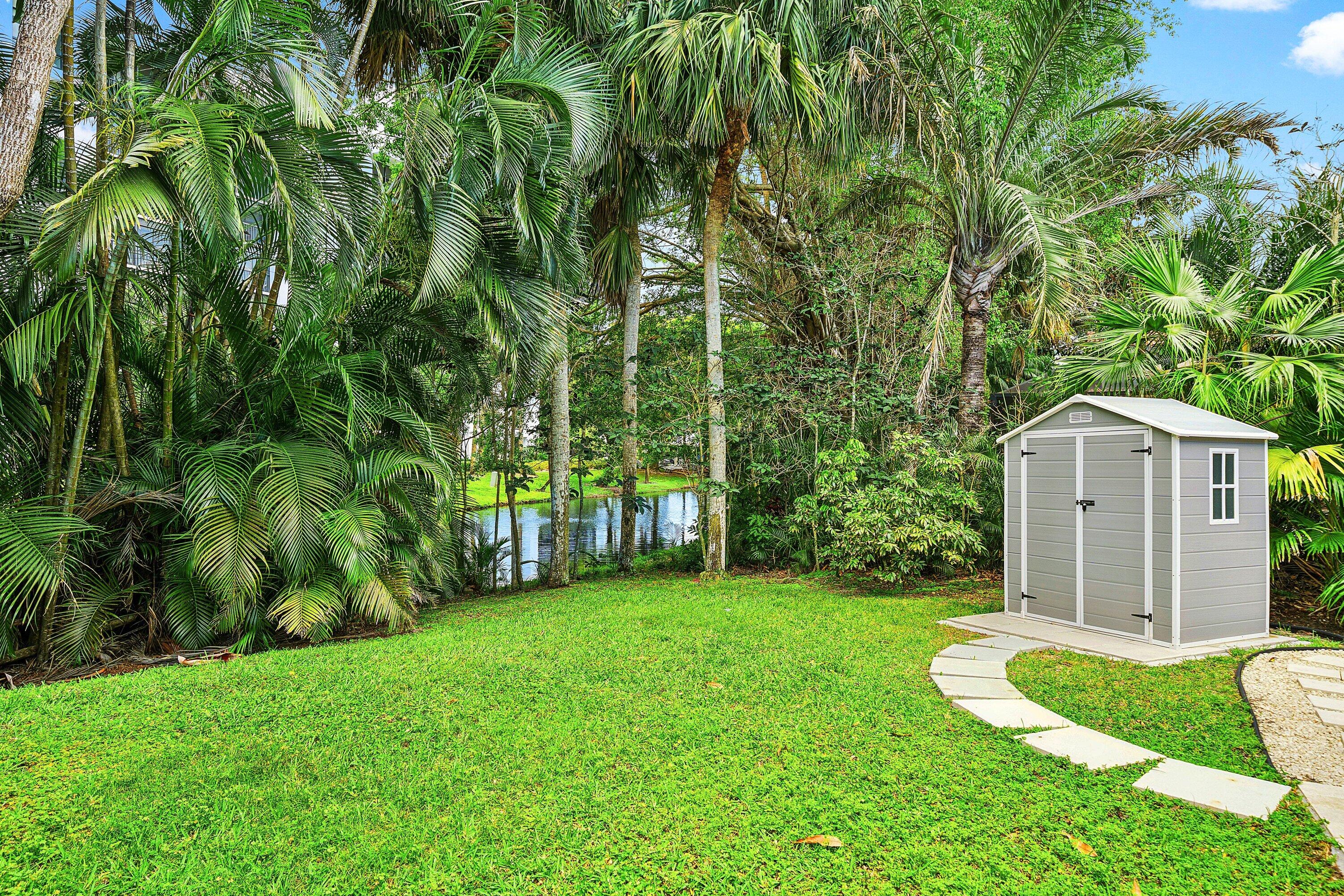 3030 Canterbury Drive Boca Raton, FL 33434 - Photo 38 of 45 a view of a backyard with potted plants and large trees
