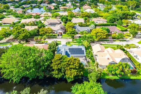an aerial view of a house with a garden and lake view