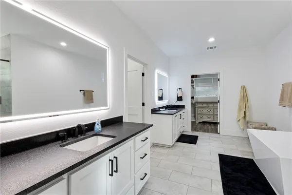 a large bathroom with a double vanity sink a large mirror and a shower