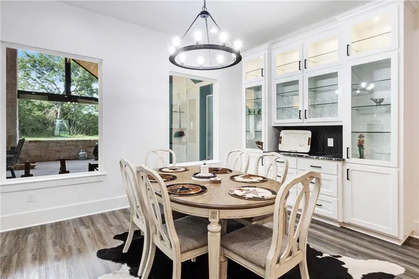 a dining room with furniture a chandelier and wooden floor