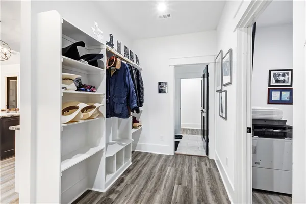 a view of walk in closet with clothes and shoes