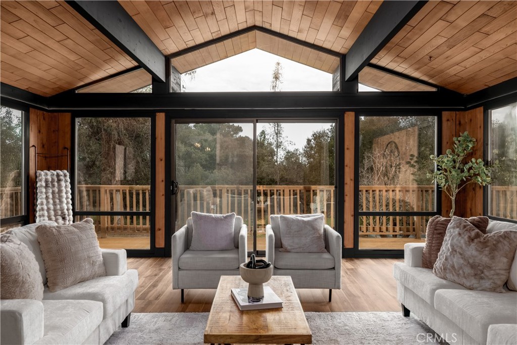 7744 West Lilac Road Bonsall, CA 92003 - Photo 15 of 60 a living room with furniture large windows and wooden floor