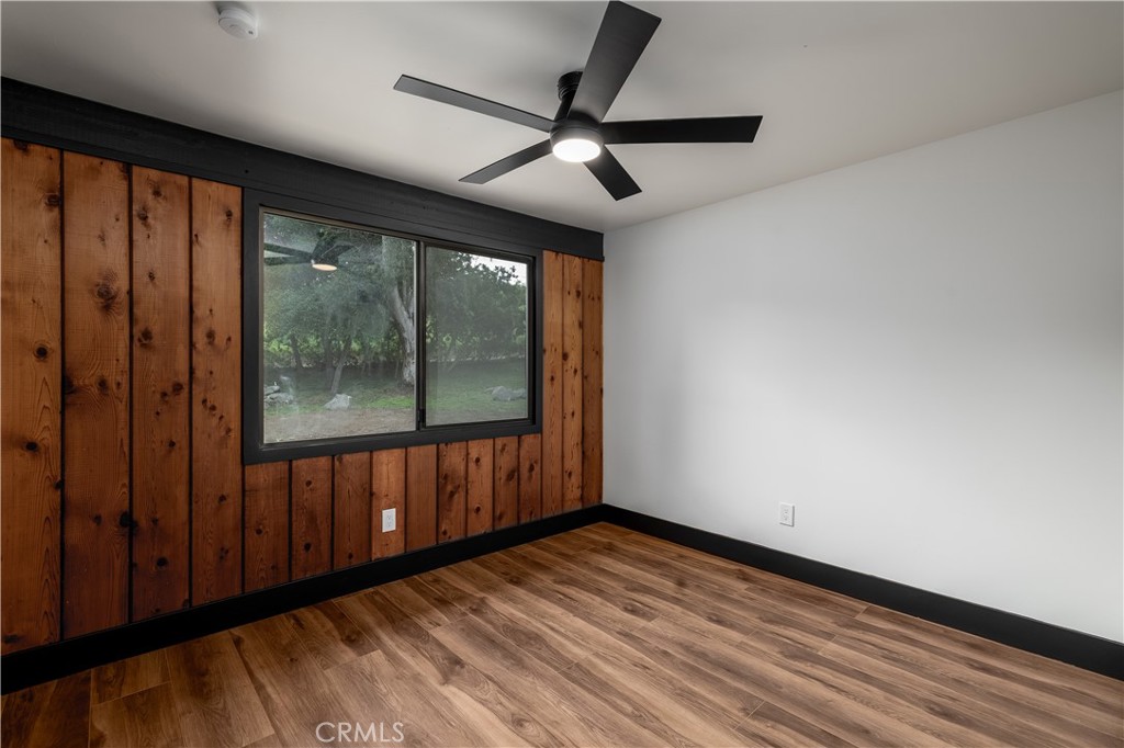 7744 West Lilac Road Bonsall, CA 92003 - Photo 27 of 60 a view of empty room with wooden floor and fan